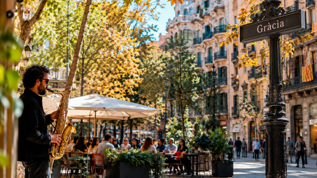 Gràcia neighbourhood in Barcelona with a lively café terrace, street musician and traditional architecture.
