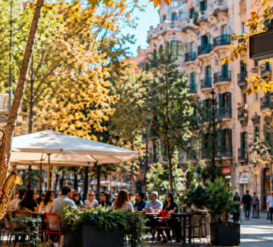 Gràcia neighbourhood in Barcelona with a lively café terrace, street musician and traditional architecture.